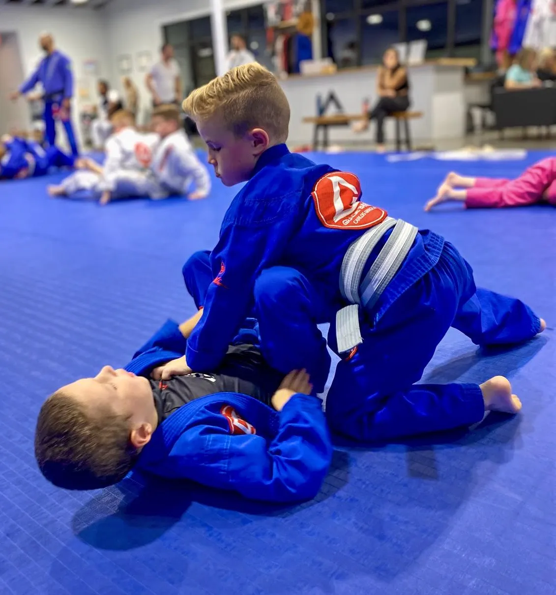 Two young students drilling a position during a Little Champions class.